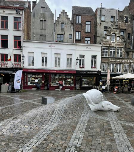 Beautiful sculpture from Antwerp. It's a boy and a dog "tucked into" the cobblestone pavement as though it's a blanket and they're sound asleep