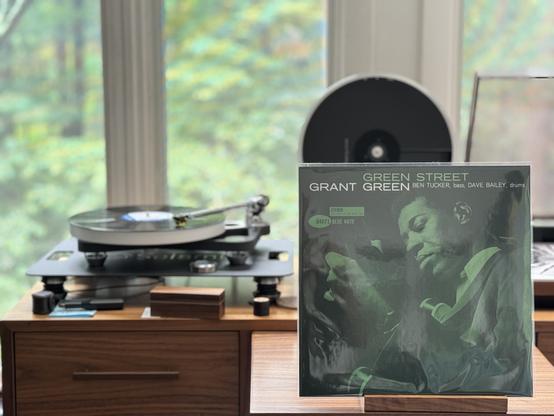 Grant Green - Green Street LP cover.

In Blue Note style, a shot of Green from below, playing his guitar, eyes closed in concentration. Title centered at the top in green print, then the artist and accompanying players.

The black LP plays on a Rega NAIA turntable to the left.