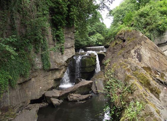 Rocks with a river running between. In the centre of the picture is a small waterfall.
