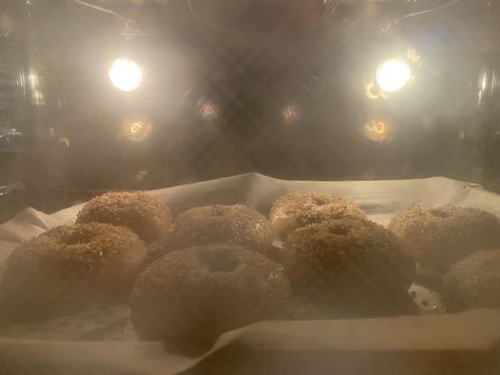 in the oven under lights, big boiled but browning bagels baking away