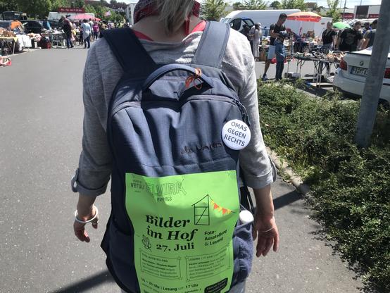 eine frau trägt einen rucksack, auf dem ein grünes plakat klebt mit der aufschrift: „bilder im hof - Bilder 
im Hof
Foto-Ausstellung und Lesung. 

Samstag, 27.07.2024

16 bis 21 Uhr

Lesung um 17 Uhr