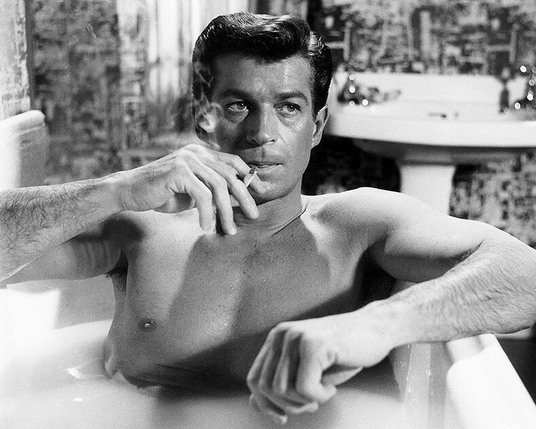 A hunky guy in a bathtub. Smoking.
