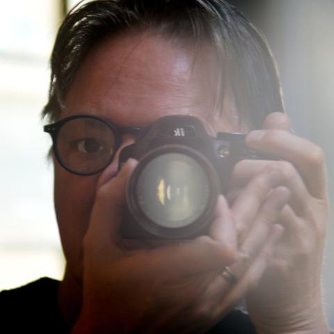 Portrait photo of Jan-Maarten Luursema holding a camera