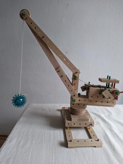 Eine Kran aus Kinder-Holzbausteinen (Matador) mit einer Abrissbirne (Massageball)