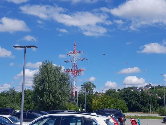 Strommast in rot-weiß lackiert mit Fernleitung.
