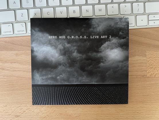 The CD cover is a black-and-white photo from somewhere in Japan of ominous dark clouds over a tile roof.