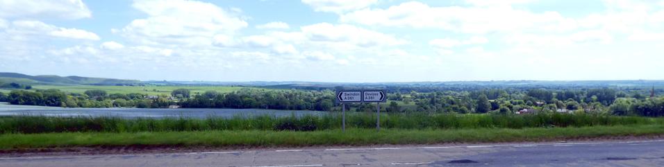 A panorama of a road, with signs pointing to Swindon & Devizes