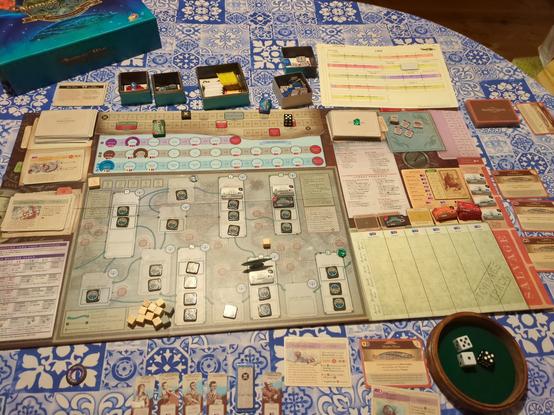 The board game _Nemo's War_, laid out on a table. A large board with a map of the continents and oceans, with many "hidden ship" tokens in the various ocean spaces. A figurine of The Nautilus represents the player's position. Various card decks and resource tracks occupy other parts of the board. A turn tracker, an imitation of an 1866 calendar, shows the game mid-way through.