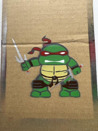 Stencil graffiti of teenage ninja turtle, the one with the sais.