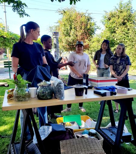 Suzi & Kemi, our artist instructors, showing us the film & casing. A table is full of supplies for the workshop in the park.