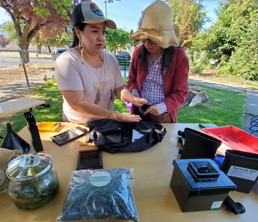 Two attendees learning to load analogue film into cases, using a portable darkroom bag.
