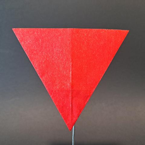 Un triangle rouge en origami, pointe en bas.