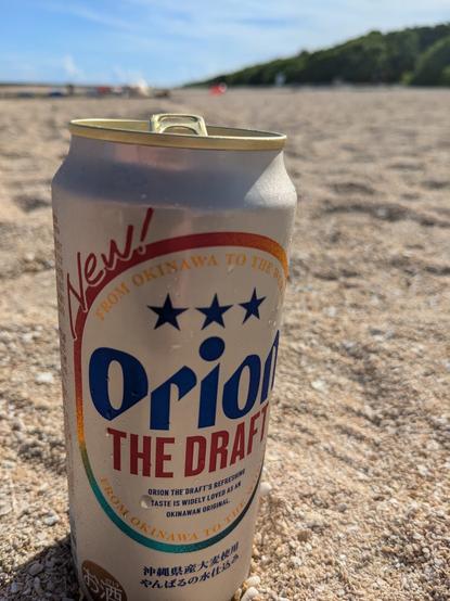 A can of Orion draft beer in the beach sand