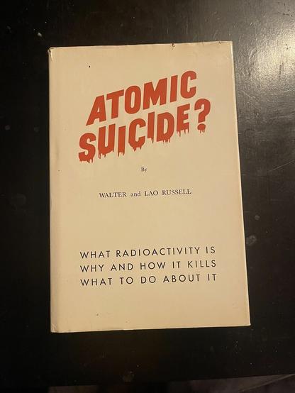 An off-white book cover.

In bold red type, the title reads:
ATOMIC
SUICIDE?

In smaller black type below:
By
WALTER and LAO RUSSELL

WHAT RADIOACTIVITY IS
WHY AND HOW IT KILLS
WHAT TO DO ABOUT IT
