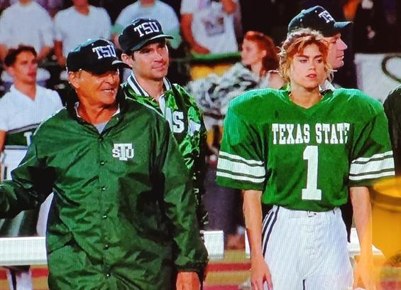 Sidelines of Texas State University football game. Shown: Assistant Coach played by Robert Loggia and field kicker played by Kathy Ireland