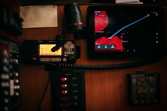 Navdesk console from a sail boat featuring a VHF radio, chartplotter, battery monitor, navigation light and various switches.
