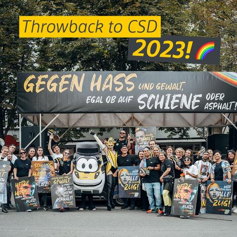 Mehrere Menschen stehen zusammen mit dem Maskottchen Bine bwegt beim Christopher Street Day in Stuttgart vor dem bwegt-Umzugswagen mit der Aufschrift "Gegen Hass und Gewalt, egal ob auf Schiene oder Asphalt". Darüber eingefügt der Text: "Throwback to CSD 2023!" mit Regenbogen-Emoji