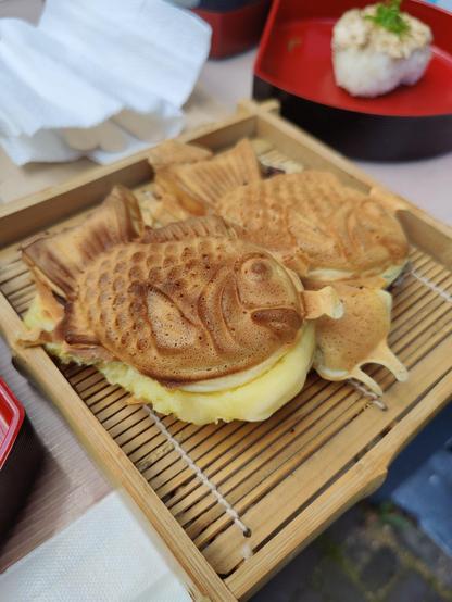 Two taiyaki presented on a bamboo/wooden plate