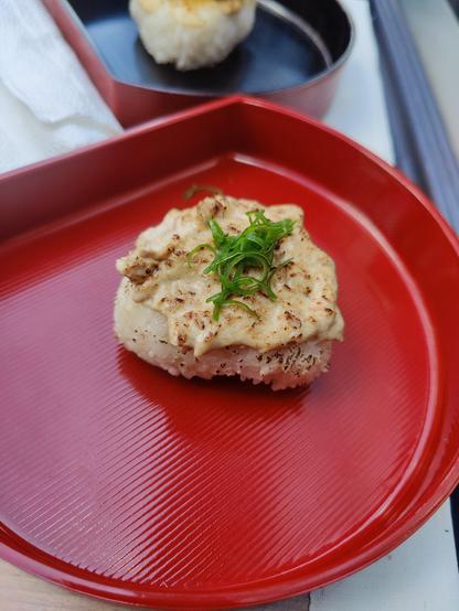 Close up of the tuna aburi onigiri 🍙 on a red plate.