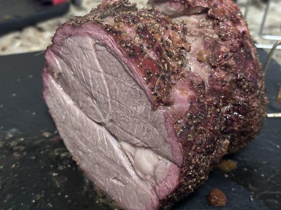 Close-up of a sliced piece of seasoned, roasted boneless lamb roast.
