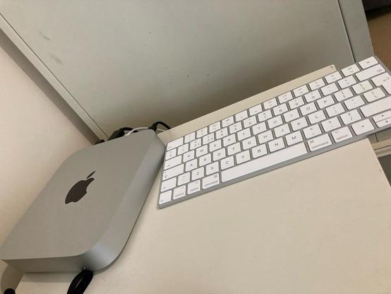 Image of an M2 Mac mini next to an Apple Magic Keyboard.
