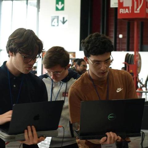 3 des membres de l'équipe travaillent sur leur ordinateur pendant la finale nationale