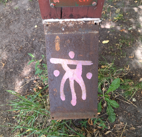White symbol on a rusted piece of metal