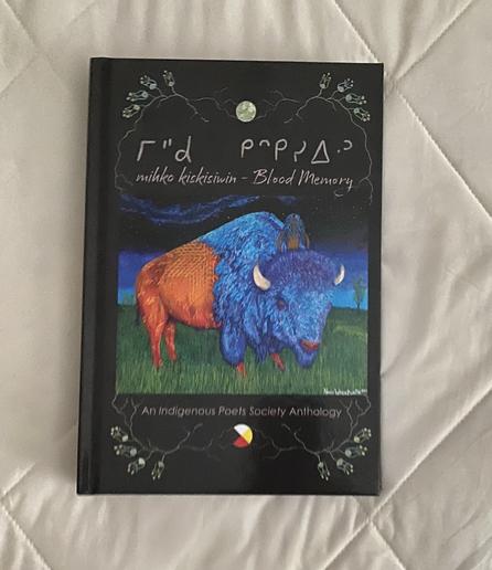 A book titled "mihko kiskisiwin - Blood Memory: An Indigenous Poets Society Anthology." The cover features a vibrant illustration of a bison with blue and orange fur standing on grass, under a night sky with a moon and tree.