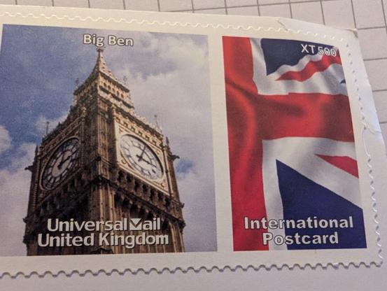 Detail einer Internationalen Briefmarke der Universal Mail aus UK mit dem Glockenturm von Big Ben links und einer partiellen UK Flagge rechts.