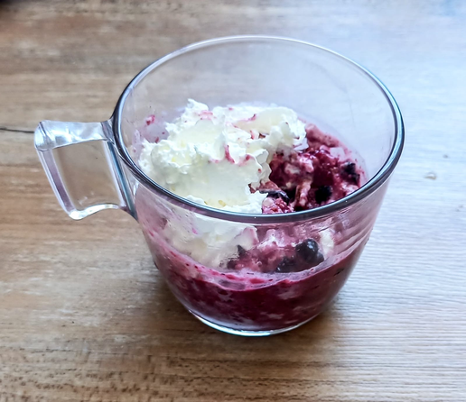 in einer Glastasse das Gemisch aus Biscotti, Beeren und Schlagsahne, obendrauf auch noch extra etwas Schlagsahne.