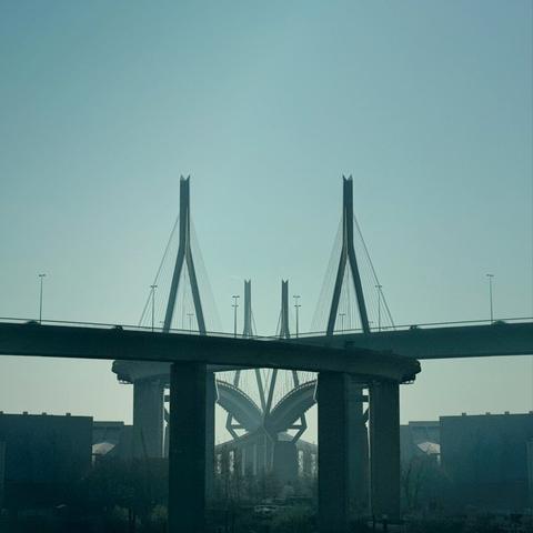 Double exposure of Hamburg‘s Köhlbrand Bridge on a hazy early morning. The two bridges shown seem to be intertwined.