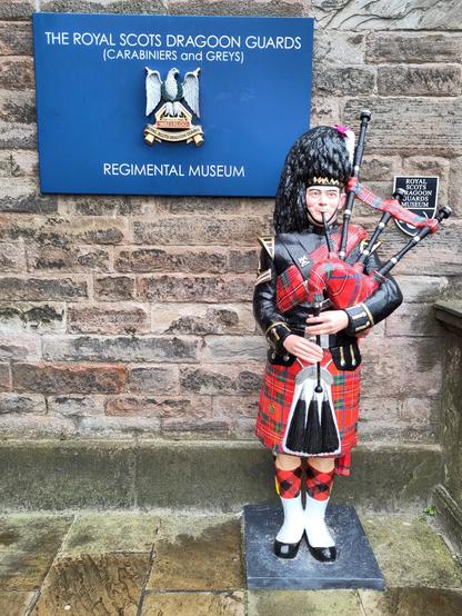 The royal Scotts Dragoon Guards (Carabiniers and Greys) regimental museum with a replica bagpipe player in front.