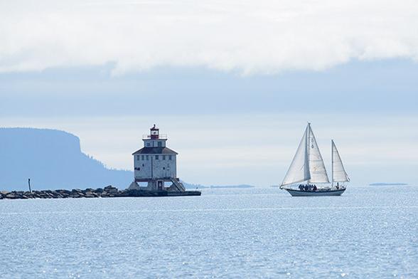 The lighthouse is just left of the middle of the photo.
The sailboat is one quarter from the right of the photo.
The stick with the Bald Eagle is just right from thr left edge of the photo.