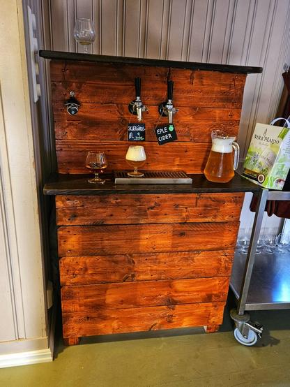 Bartop with two faucets. Left sign reads "Skjærgårdsøl", right sign reads "Eplecider".