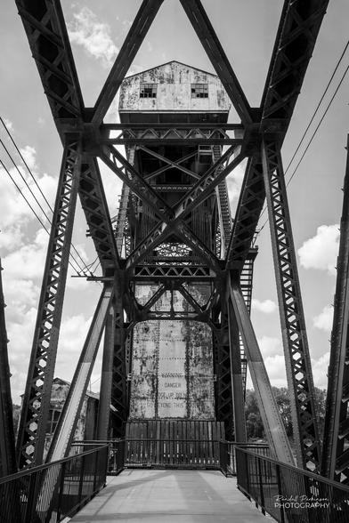 View looking towards the lift span of an old steel truss railroad vertical lift bridge.