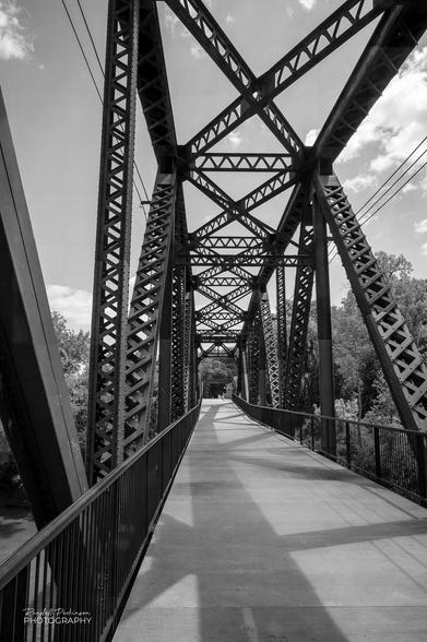 View of the approach span of an old railroad vertical lift bridge rehabbed for pedestrian use.