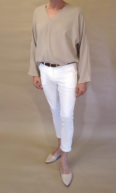 I’m wearing a loose closed khaki blouse with v-neck, white pencil pants with high ankles and a pair of light peach velvet ballerinas. Seen from the front as I put left foot forward.