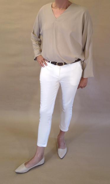 I’m wearing a loose closed khaki blouse with v-neck, white pencil pants with high ankles and a pair of light peach velvet ballerinas. Seen from the front as I put right foot forward to one side.