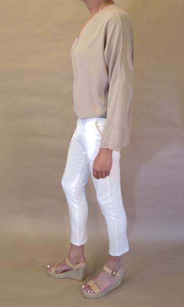 I’m wearing a loose closed khaki blouse with v-neck, white pencil pants with high ankles and a pair of beige wedge heeled espadrille sandals. Seen my left.