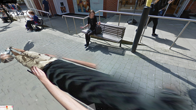 a glitched elongated image of a man lies flat on a pedestrian concourse, while other people continue their daily business, oblivious to the 2D collapse in reality.