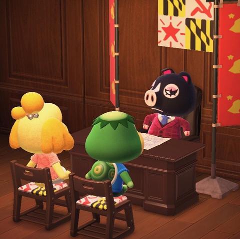 Animal Crossing: New Horizons screenshot. Image shows Agnes (black pig) wearing a reddish tweed coat with a blue tie sitting at a desk in a brown wooden paneled room. In front of the desk are Kapp'n and Isabelle sitting in chairs. Behind her and on the chairs is a flag that looks like the Maryland state flag, except the upper right and lower left corners have been replaced with a hammer and sickle and star respectively. Banner flags are on either side of Agnes.