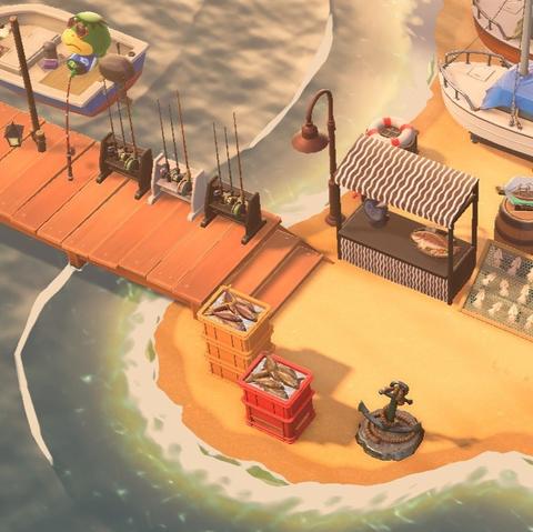 Animal Crossing: New Horizons screenshot. Image of a beachfront adjacent to a dock with Kapp'n's boat on the left. On the dock are a few sets of fishing rods. Along the southern edge of the beach are crates of fish. Immediately north of that is a fish sales booth and a rack of some small squid. There are boats seen just above the booth along the water's edge.