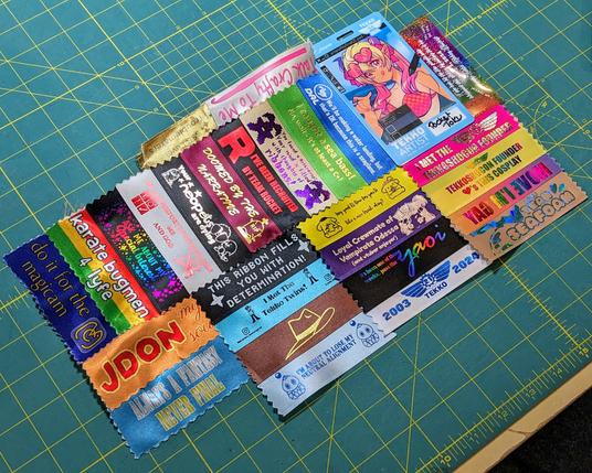a Tekko artist badge with 27 different ribbons stuck on in multiple directions