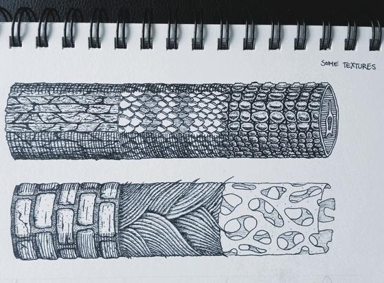 Part of a sketchbook page with black fineliner drawings of two horizontal cylindrical forms, each split into three segments of different textures.

Top cylinder: Tree bark, snake scales, alligator scales.
Bottom cylinder: Bricks, thick wavy fibers, thin hollow coral-like structure with holes.