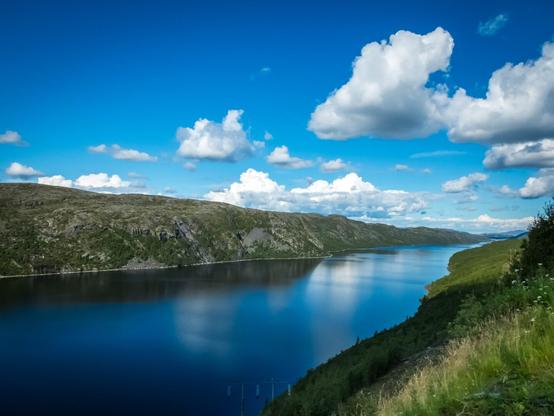 Summer view of a fjord, with blue skies.