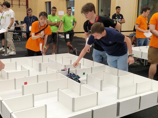 Épreuve de compétition de FLS contre une autre équipe. Au premier plan on aperçoit le terrain Robocup Maze dans lequel évolue le robot de FLS.