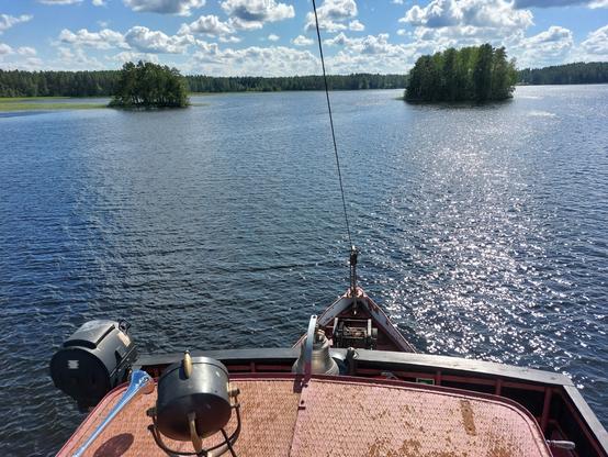 Laivan puusauna lämpesi matkan aikana, ja saunomispaikaksi ankkuroitiin jokin Saimaan selistä. Kuvan otin kiipeämällä laivan katolle, jota näkyy etualalla, sitten paljon kai juomapuhdasta vettä (ainakin täysin hajutonta), saaria ja poutaiseksi kääntynyttä säätä.