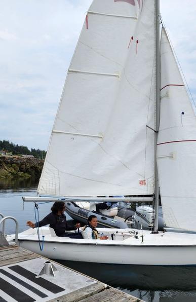 Me & young sailing instructor in sailboat. Being towed out by Zodiac boat.