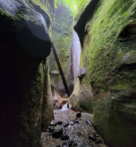 Waterfall seen through cave like trail.
