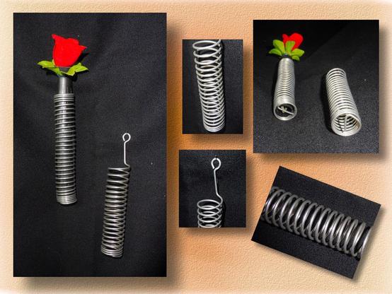 Collage mit Detailfotos einer Rosenvase: Aluminiumdraht zu einer Spirale gewickelt, an einem Ende eine Öse zum Aufhängen ann der Wand. In der Spirale ein schwarzes Kunststoffröhrchen, darin eine rote Rose.

Collage with detailed photos of a rose vase: aluminium wire wound into a spiral, with an eyelet at one end for hanging on the wall. Inside the spiral is a small black plastic tube containing a red rose.